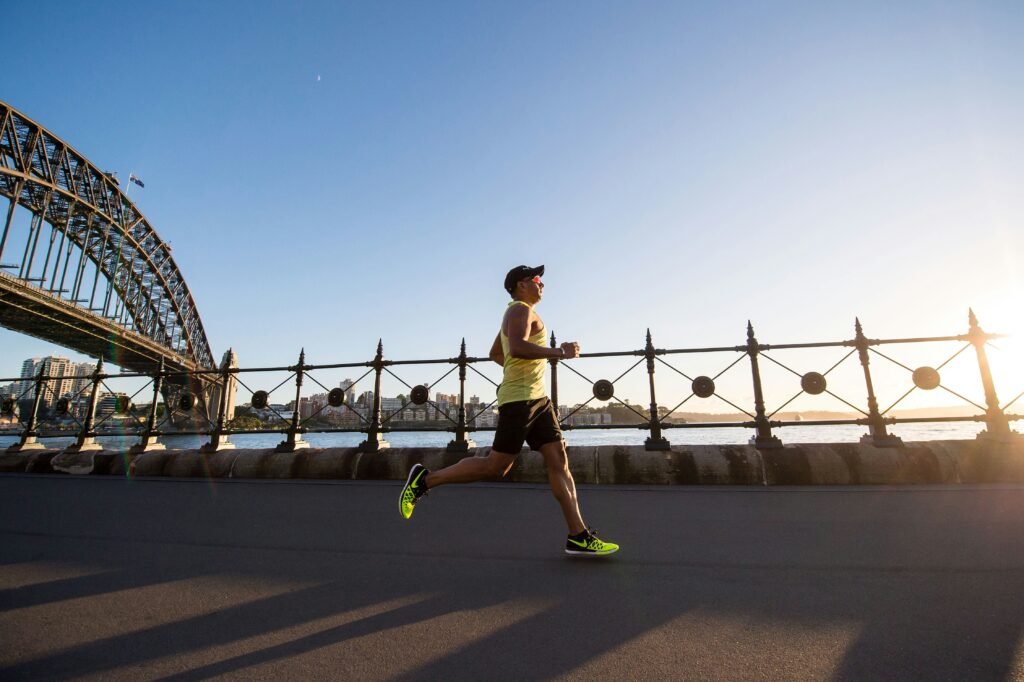 Man wearing a yellow shirt running a long a waterfront