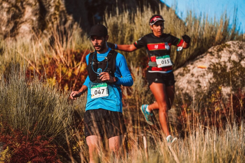 Two men running a downhill trail