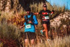 Two men running a downhill trail